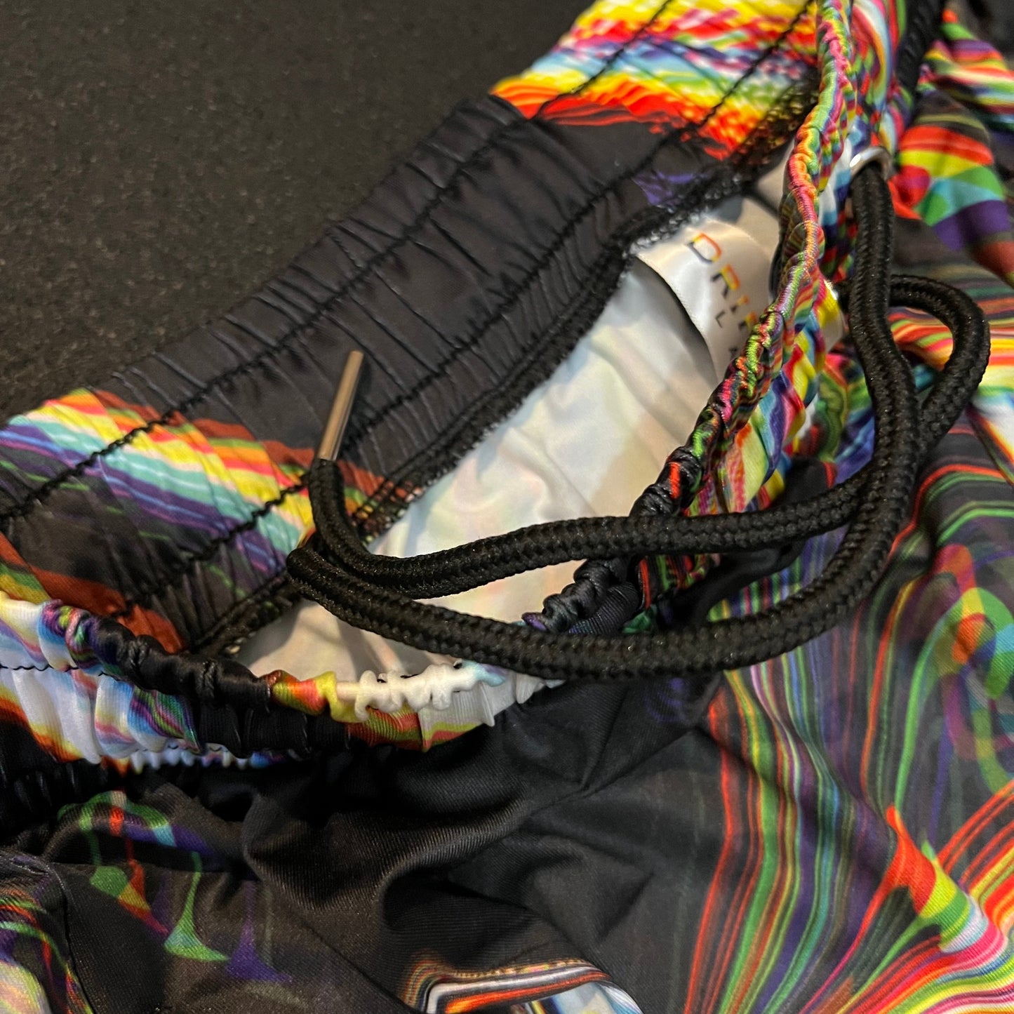 Close-up of a colorful jacket with a black cord, on a dark background