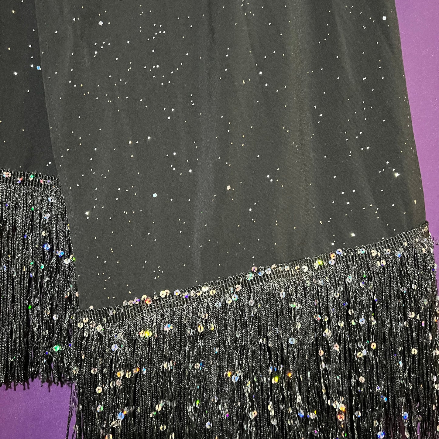 Black sequin fabric with a purple background