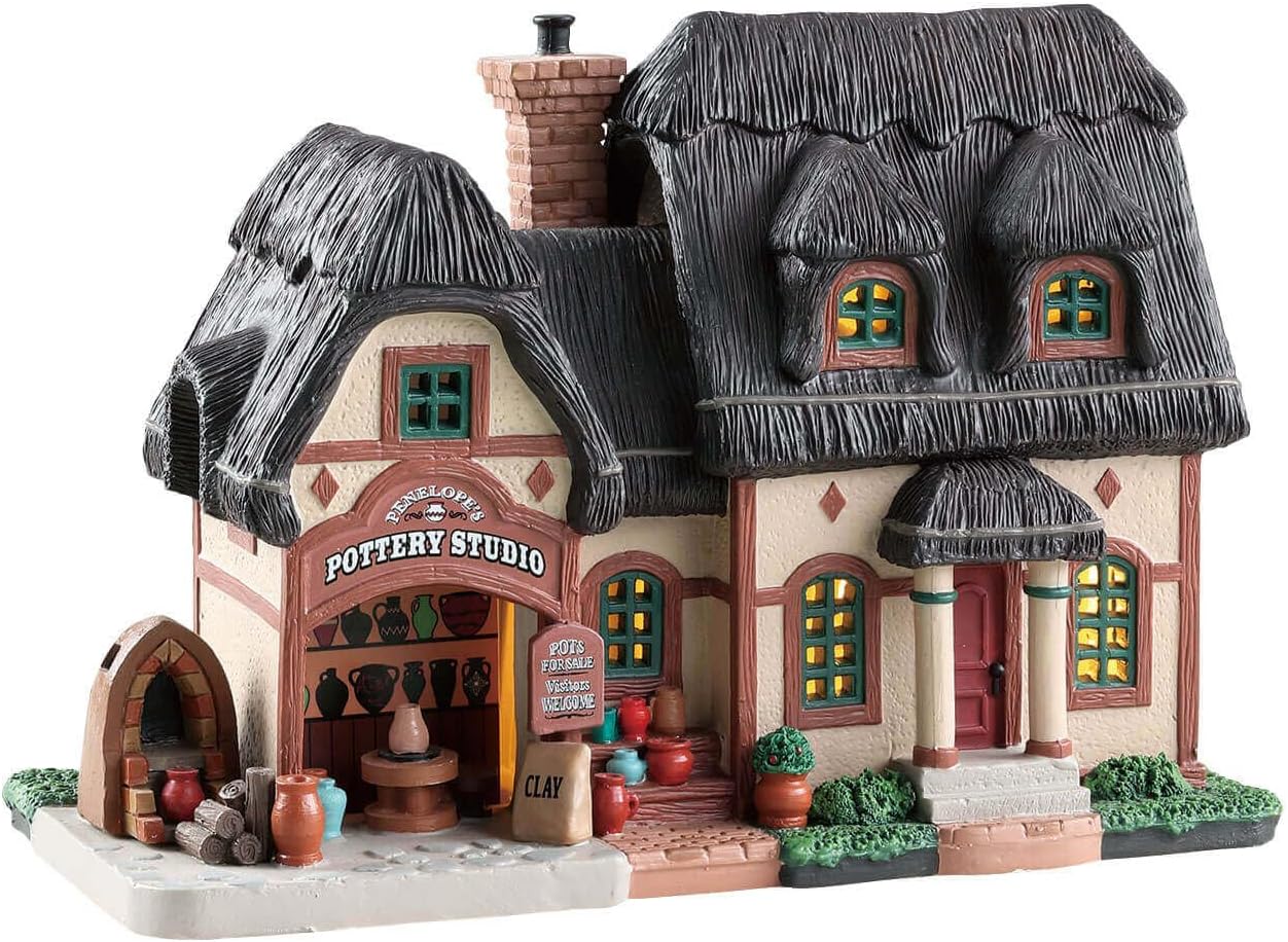 Model of a pottery studio with thatched roofs and decorative elements on a white background