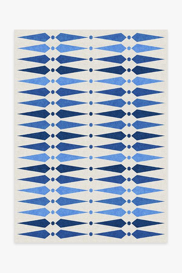 Rug with blue and white geometric pattern on a plain background
