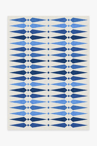 Rug with blue and white geometric pattern on a plain background