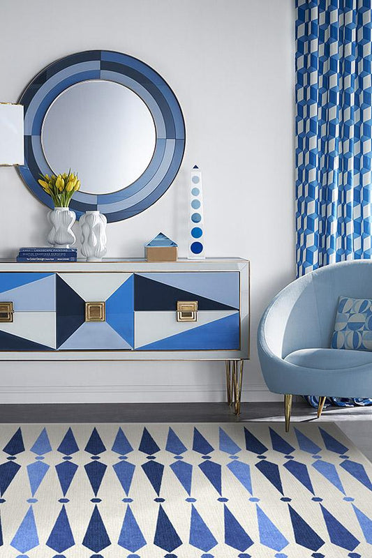 Modern interior with blue and white geometric design furniture, mirror, and decor.