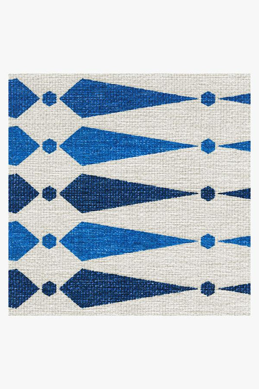 Geometric patterned rug with blue and white design on a plain background