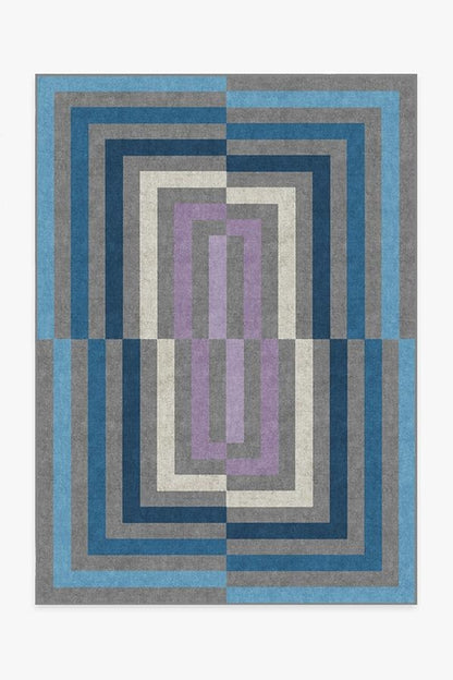 Geometric patterned rug with blue, gray, and purple colors on a white background