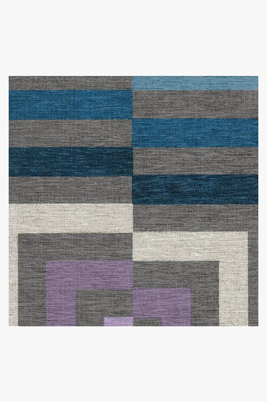 Geometric patterned rug with blue, gray, and purple squares on a white background