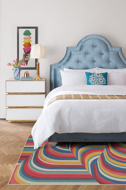 Bedroom with a colorful rug, bed, and nightstand.