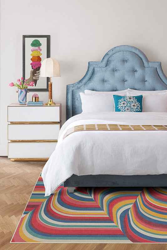 Bedroom with a colorful rug, bed, and nightstand.