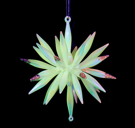 Decorative star-shaped ornament with a glowing green and pink color on a black background