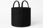 Black woven basket with handles on a white background