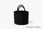 Black woven basket with handles on a white background