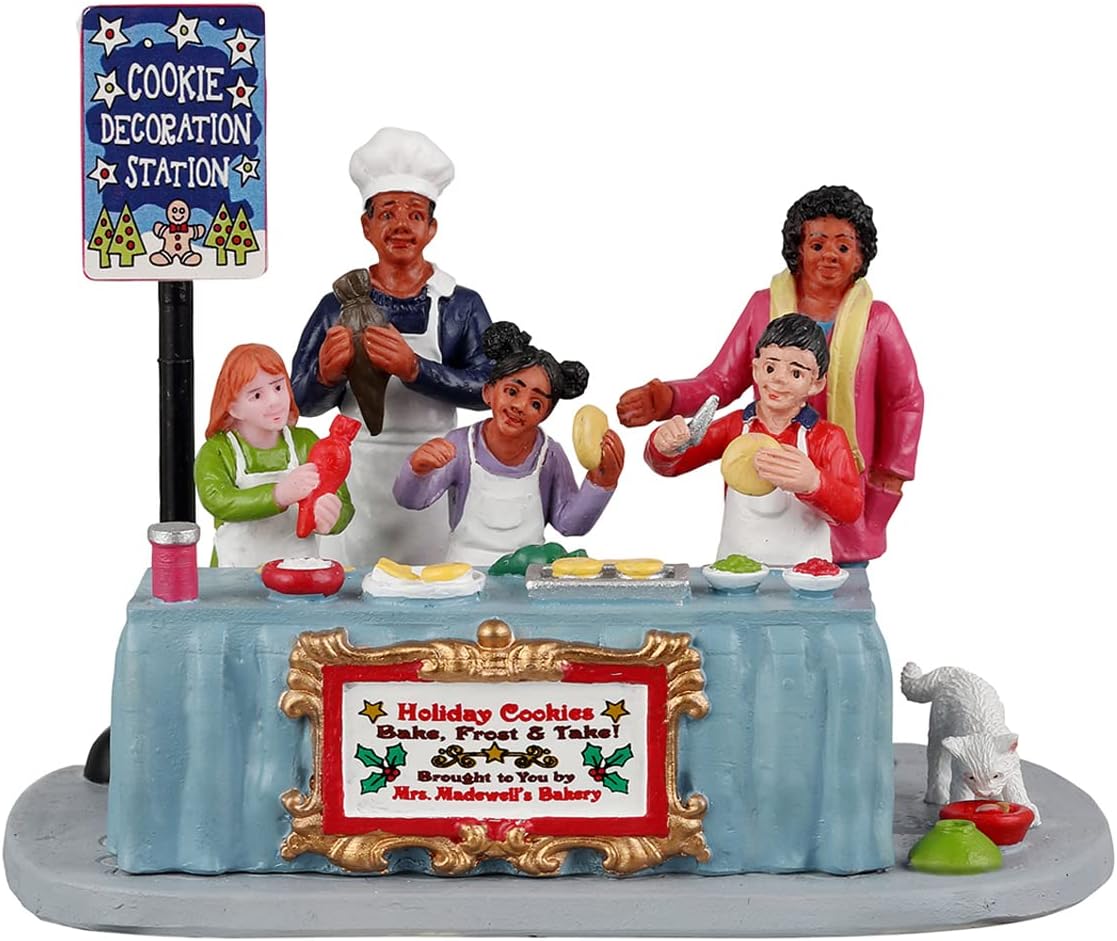 Decorative figurine of a cookie decoration station with people around a table.
