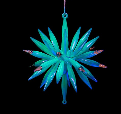 Decorative teal star-shaped ornament with a black background