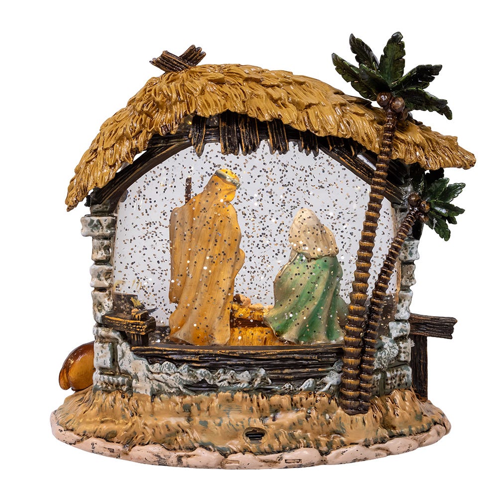 Decorative nativity scene with stable, figures, and palm tree on a white background