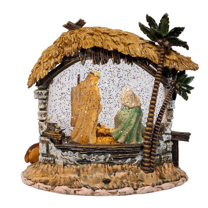 Decorative nativity scene with stable, figures, and palm tree on a white background