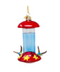 Hummingbird feeder with red top and clear body on a white background